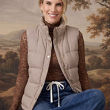 Model wearing a graced Karla gingham puffer vest in beige and white over a brown lace top and blue jeans.