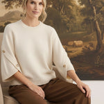 graced The Layla cream knit top with button-detailed sleeves, worn by a model in a relaxed fit.