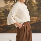 graced The Layla cream knit top with button-detailed sleeves worn by a blonde model with brown trousers