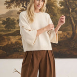 graced The Layla cream knit top with button-detailed sleeves worn by a blonde model in a relaxed fit