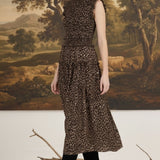 graced Leah sleeveless midi dress in leopard print with a smocked bodice and ruffled shoulders on a model