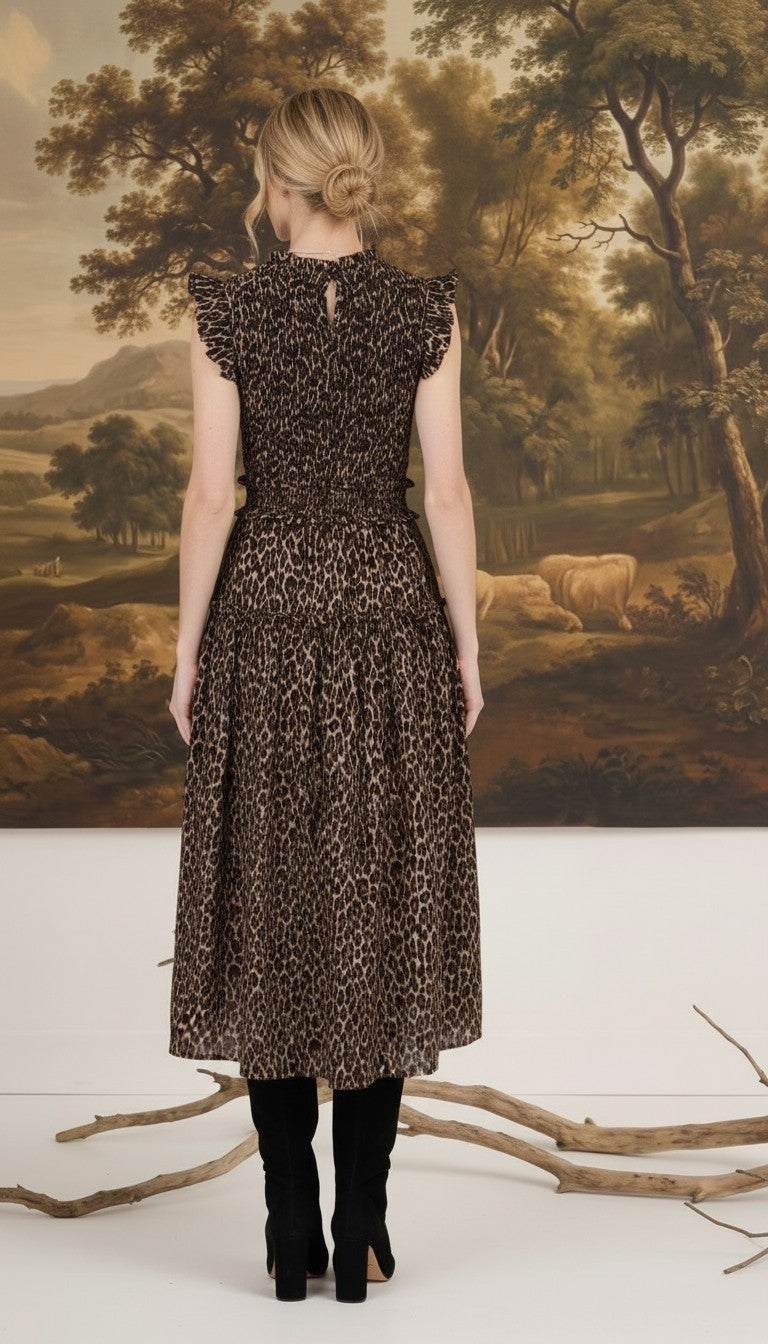 Back view of a woman wearing a graced leopard print sleeveless midi dress with a smocked waist and ruffled shoulders.