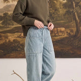 graced soft denim barrel pants in light wash cotton with patch pockets worn by a woman with an olive green sweater