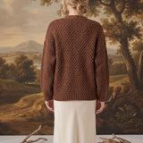 Back view of a model wearing a mocha chunky knit cardigan by graced, featuring a textured pattern and relaxed fit.