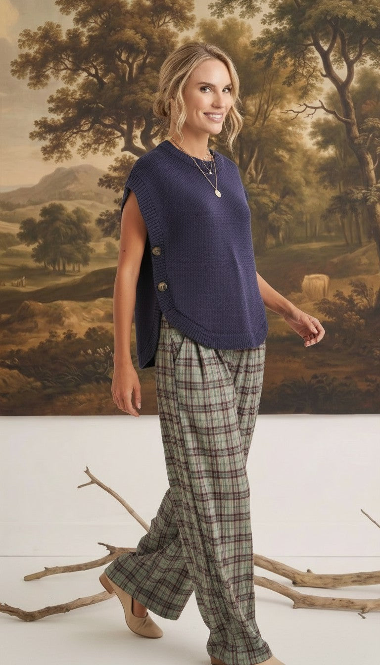 graced navy crew neck sweater vest with side button detail worn by a model with plaid trousers