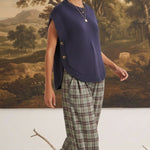 graced navy crew neck sweater vest with side button detail worn by a model with plaid trousers