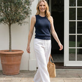 Graced navy blue knit tank top with traveling rib trim, paired with white linen pants.
