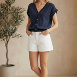 Navy sleeveless button-down top by in February, casual basic top with collar and front buttons, displayed on a mannequin.