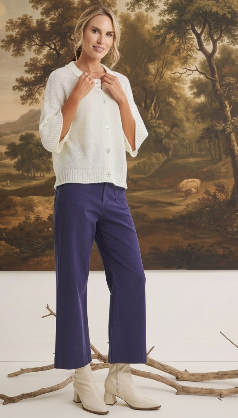Model wearing graced navy wide-leg Darcy pants with pocket details and a white button-up cardigan