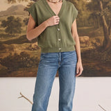 graced model wearing an olive green sleeveless cotton button-down top with blue jeans in a studio setting