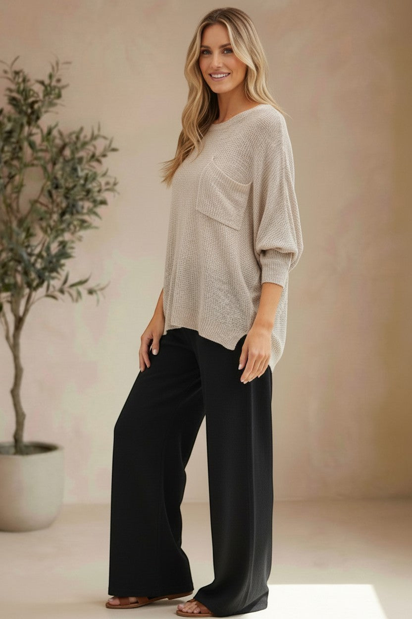 Model wearing a graced pebble dolman long sleeve knit sweater with a chest pocket and relaxed fit.