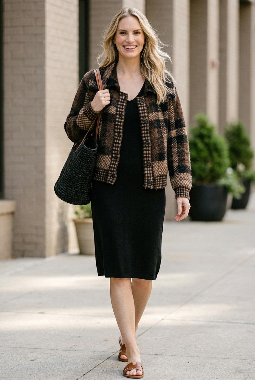graced plaid button-down cardigan in brown and black worn by a smiling woman over a black midi dress