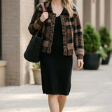 graced plaid button-down cardigan in brown and black worn by a smiling woman over a black midi dress