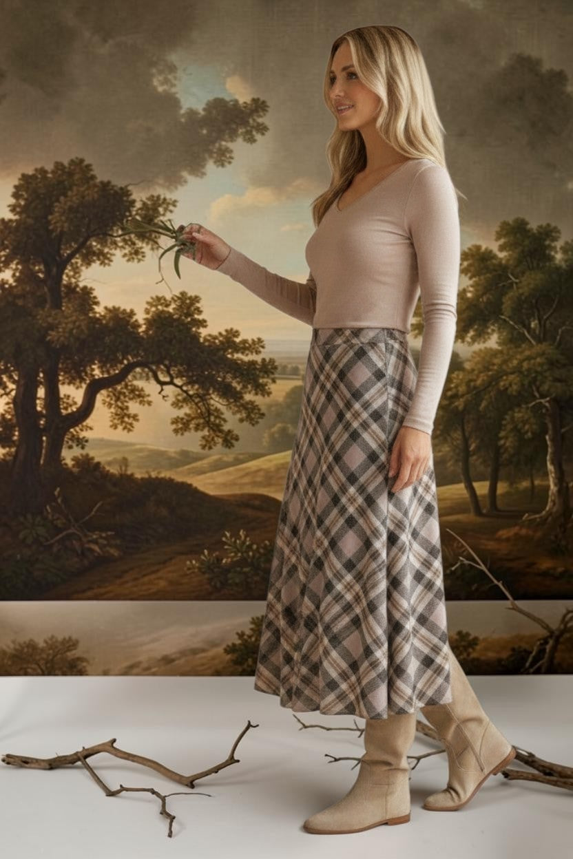 A model wearing a graced A-line midi skirt with a beige and black plaid pattern, paired with a long-sleeve top.