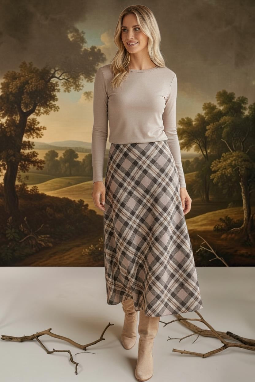 graced A-line midi skirt in a beige and black plaid pattern worn with a long-sleeve top and suede boots