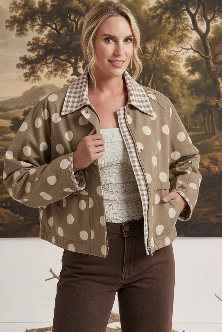 Model wearing a graced Julia polka dot canvas twill jacket in tan with a gingham collar, styled over a white top.
