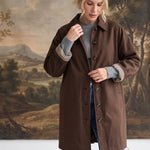 graced The Raven midi trench coat in brown with a classic collar and gingham check lining, worn by a blonde model.