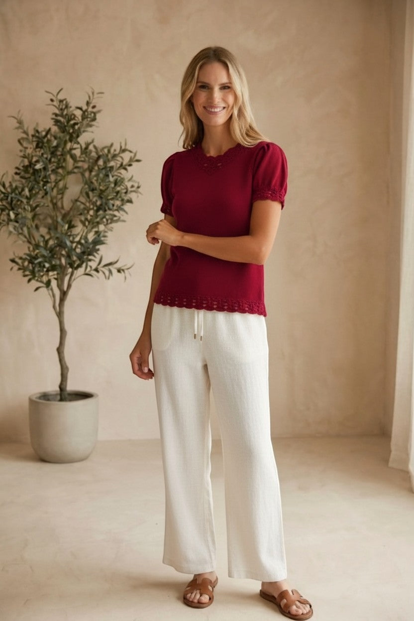 Red knit scallop trim puff sleeve top by Camellia, featuring ruffled details and a stylish, feminine design.