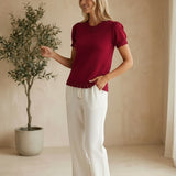 Red Camellia knit top with scallop trim and puff sleeves, featuring a stylish, feminine design.