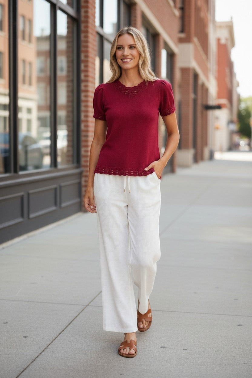 Red Camellia knit top with scallop trim and puff sleeves, featuring a stylish feminine design and detailed sleeve accents.