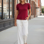 Red Camellia knit top with scallop trim and puff sleeves, featuring a stylish feminine design and detailed sleeve accents.