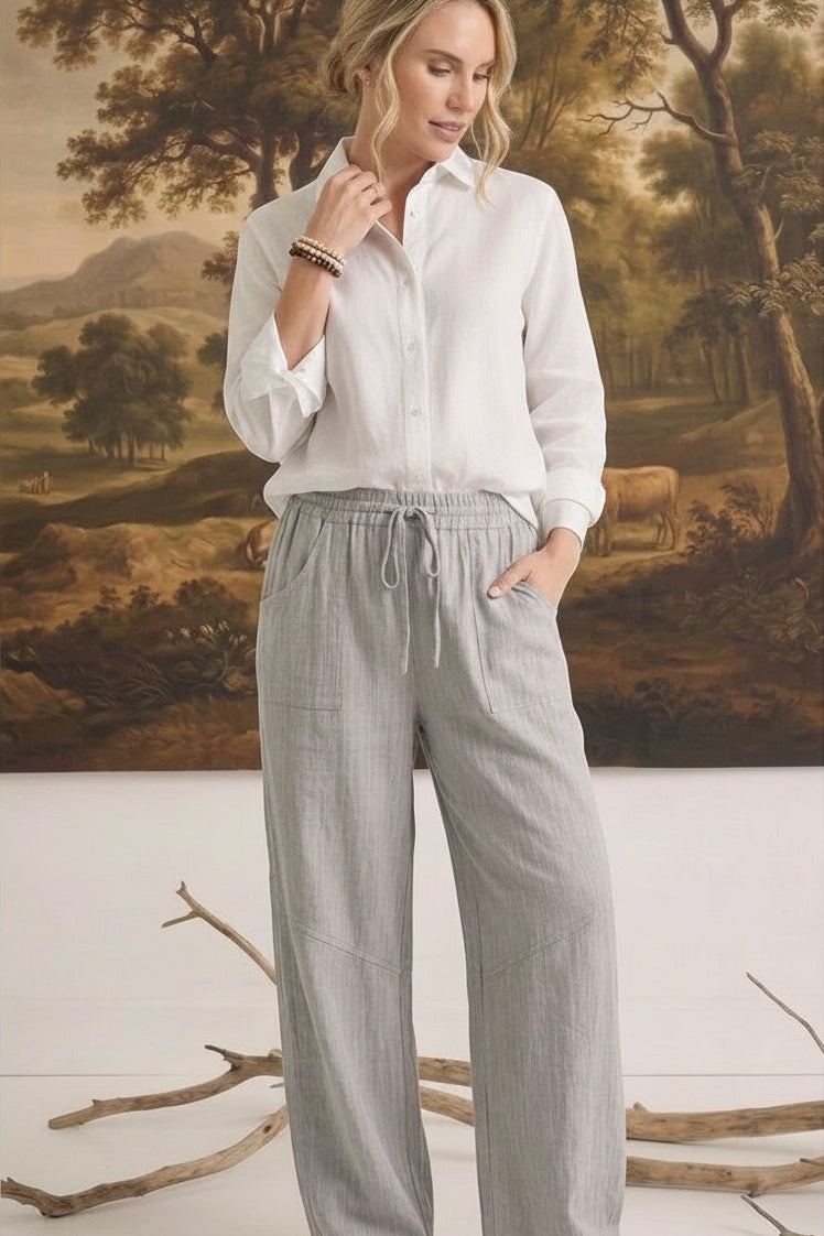 graced The Rita relaxed grey striped pants in a rayon-linen blend with a drawstring waist, worn with a white shirt.