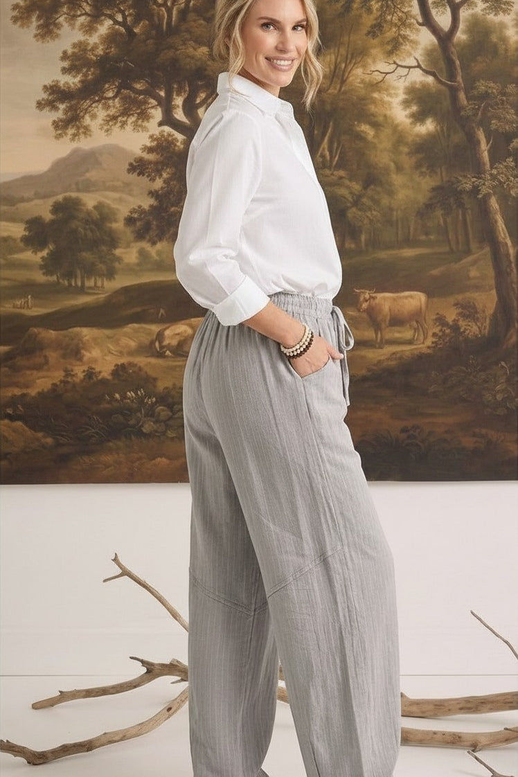 graced The Rita relaxed grey striped pants in a rayon-linen blend worn by a woman with a white button-down shirt