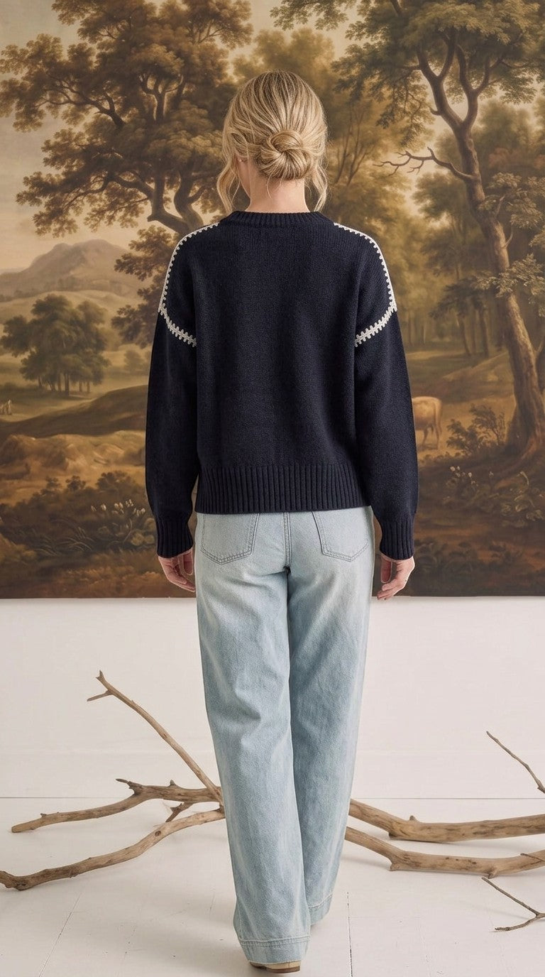 graced The Sheila Sweater in navy blue with white crochet-style shoulder detailing, worn with light wash jeans