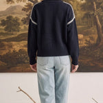 graced The Sheila Sweater in navy blue with white crochet-style shoulder detailing, worn with light wash jeans