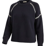 graced The Sheila Sweater in navy blue with cream-colored whipstitch detailing along the raglan sleeves
