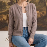 graced crew neck button down cardigan in a soft taupe knit worn by a woman with blue jeans