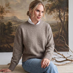 graced crew neck sweater in taupe worn by a woman with a white collared shirt underneath and light blue jeans
