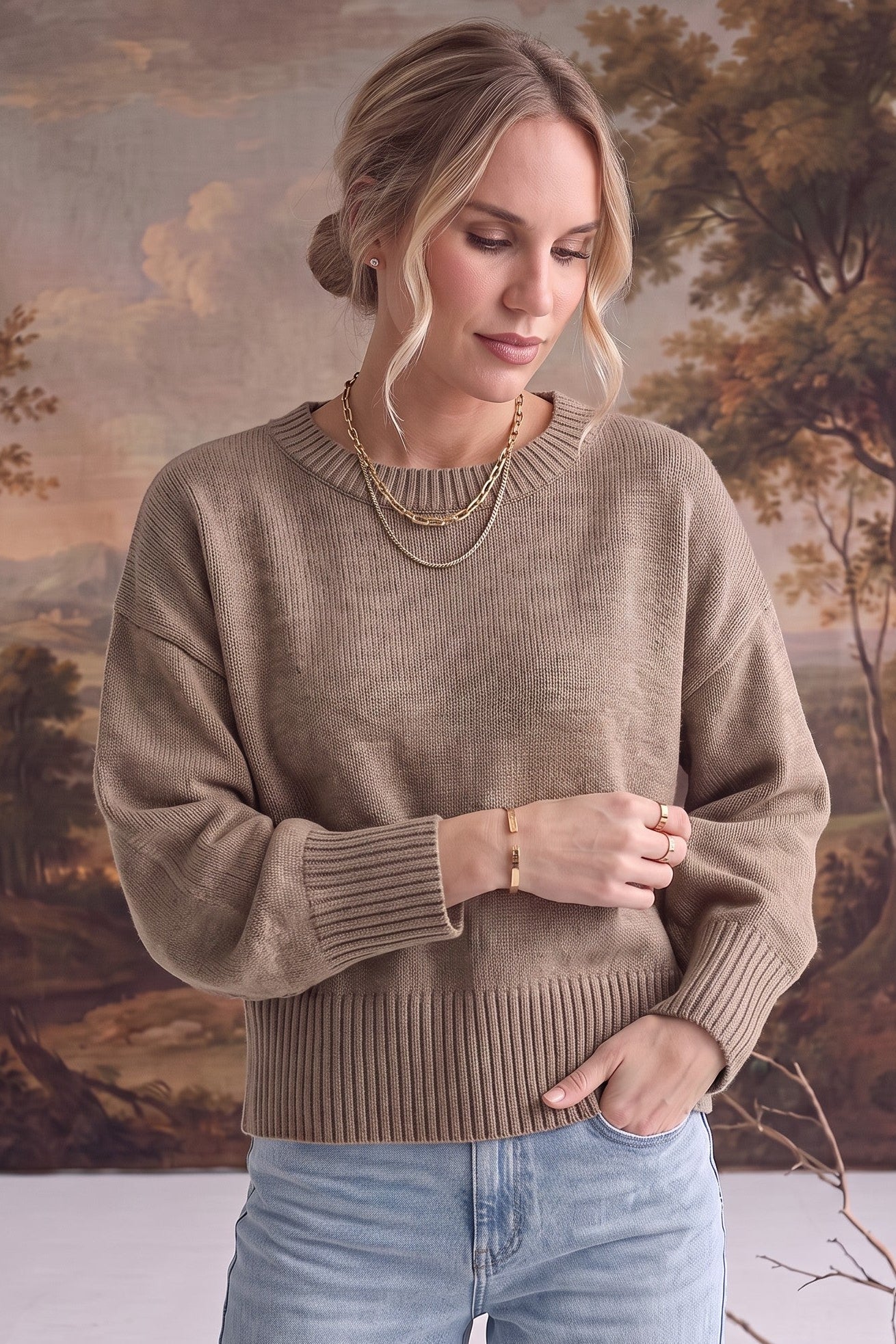 graced Eloise taupe crew neck sweater with dropped shoulders and ribbed cuffs worn by a woman with gold jewelry