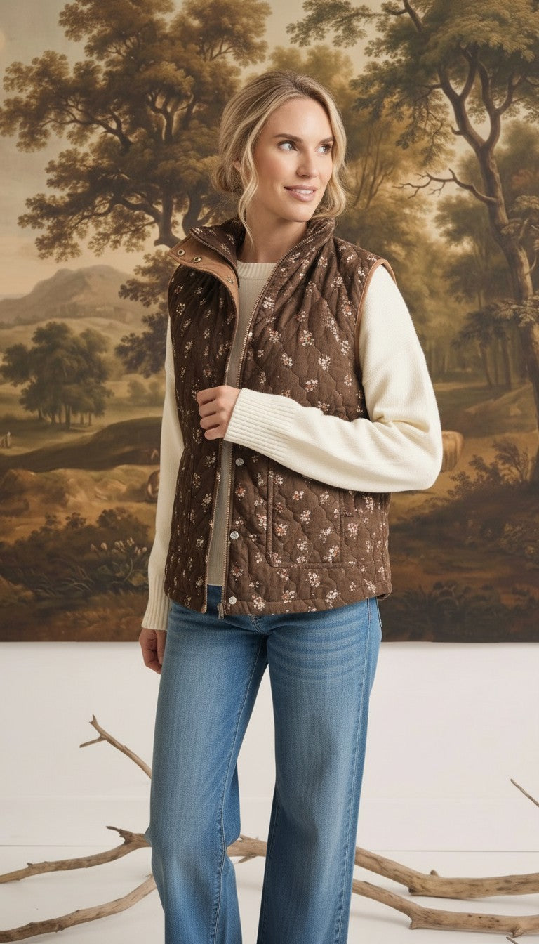 graced The Teagan Quilted Vest in brown floral cotton worn over a cream sweater and blue jeans