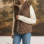 graced The Teagan Quilted Vest in brown floral cotton worn over a cream sweater and blue jeans
