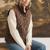 graced The Teagan Quilted Vest in brown floral cotton with a button-front closure worn over a cream sweater.