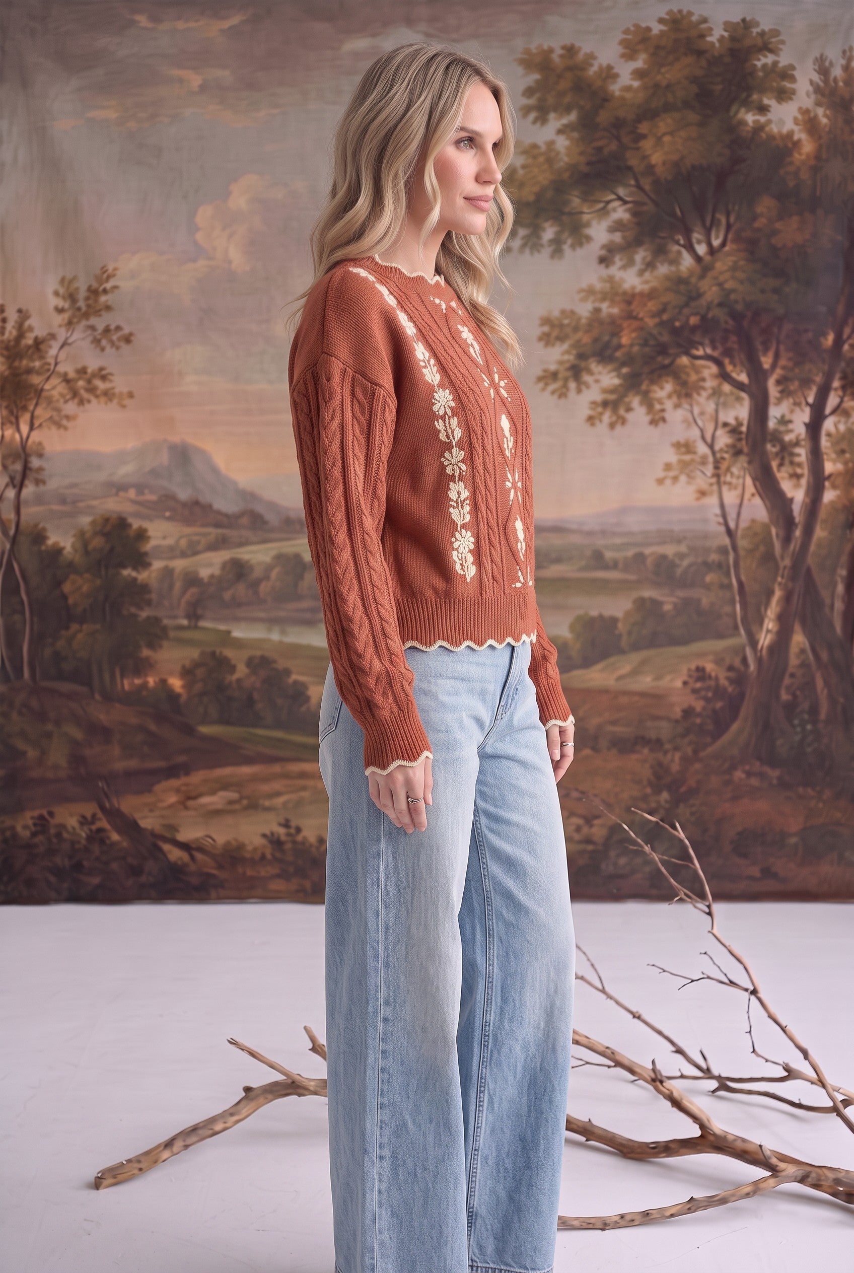 graced terracotta cable knit sweater with floral embroidery worn by a blonde model with light wash wide leg jeans