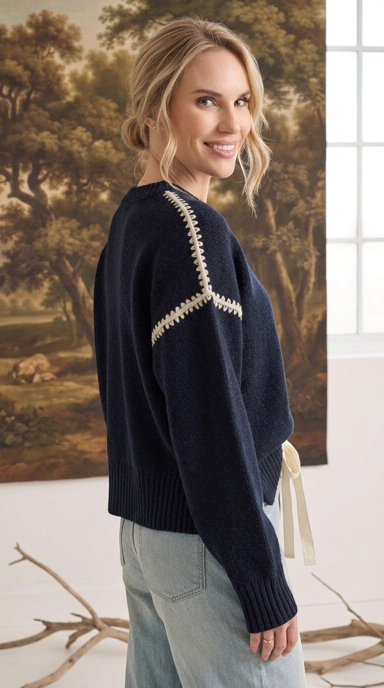 graced The Sheila Sweater in navy blue with cream contrast stitching on the shoulders worn by a smiling model