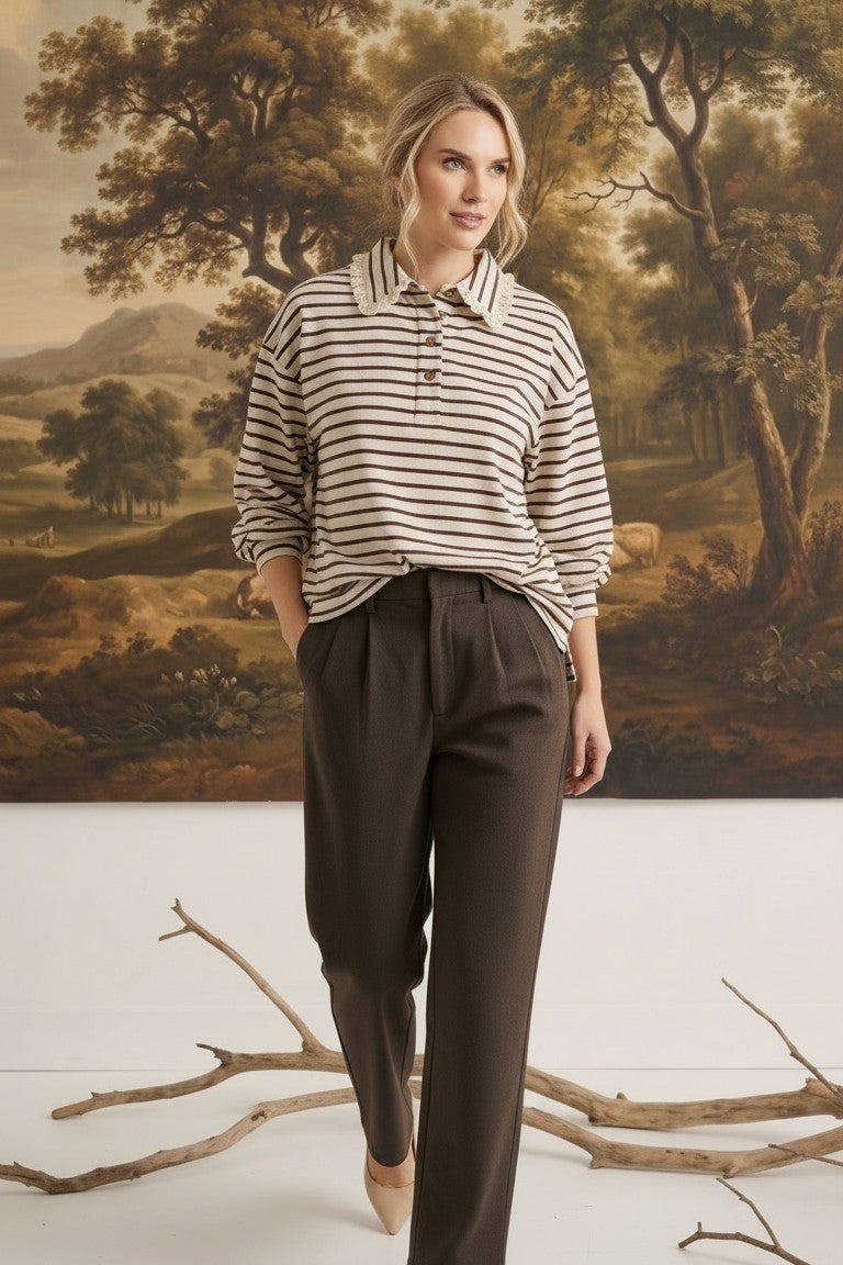 graced Tracy striped polo top with lace collar detail worn by a model with brown trousers in a studio setting