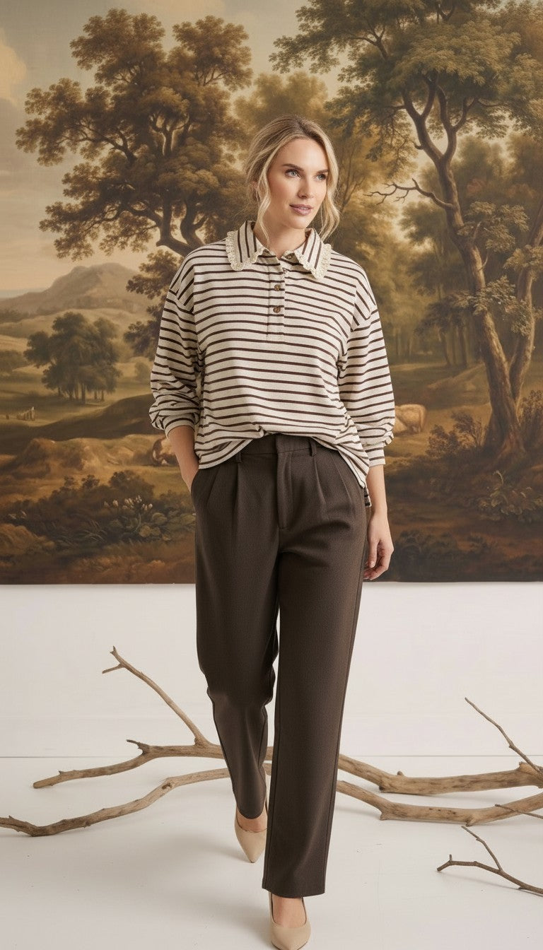 graced Tracy striped polo top with lace collar detail worn by a model with brown trousers in a studio setting