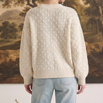 graced two tone textured weave sweater in cream worn by a woman with light blue jeans, back view