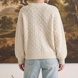 graced two tone textured weave sweater in cream worn by a woman with light blue jeans, back view