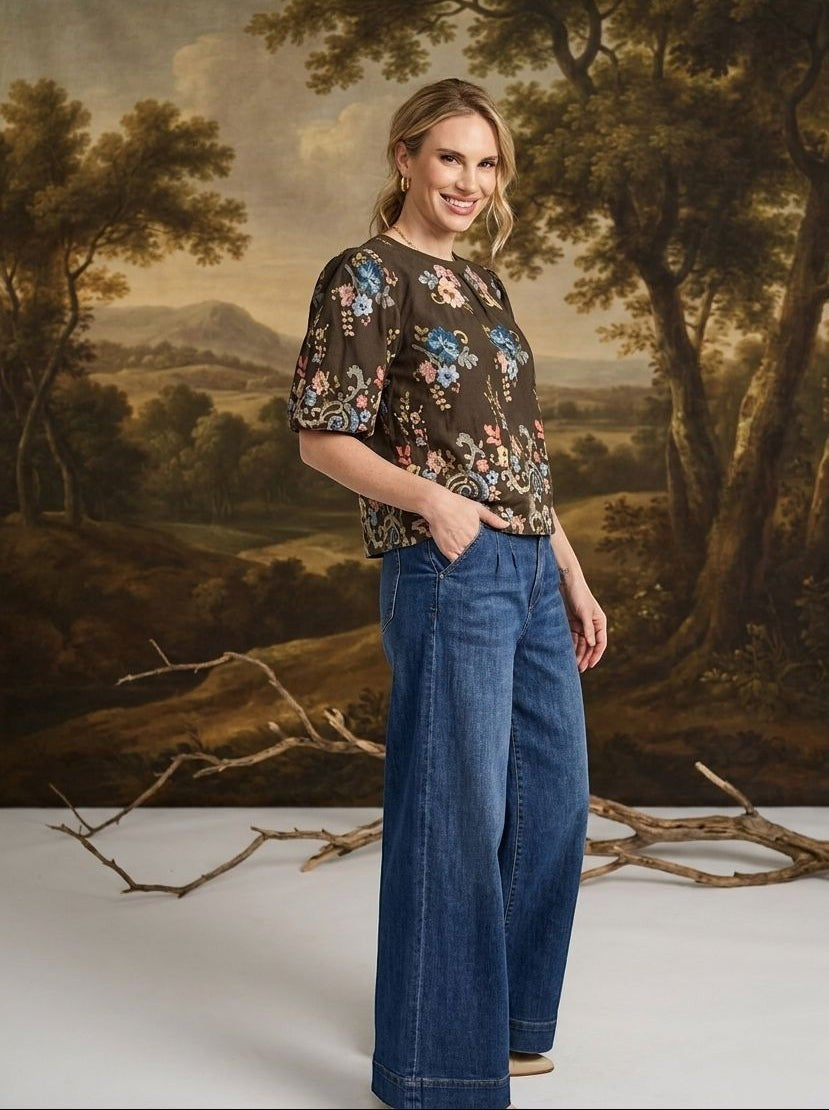graced washed dark denim tie-front pants with a relaxed wide-leg fit worn by a smiling woman in a studio setting