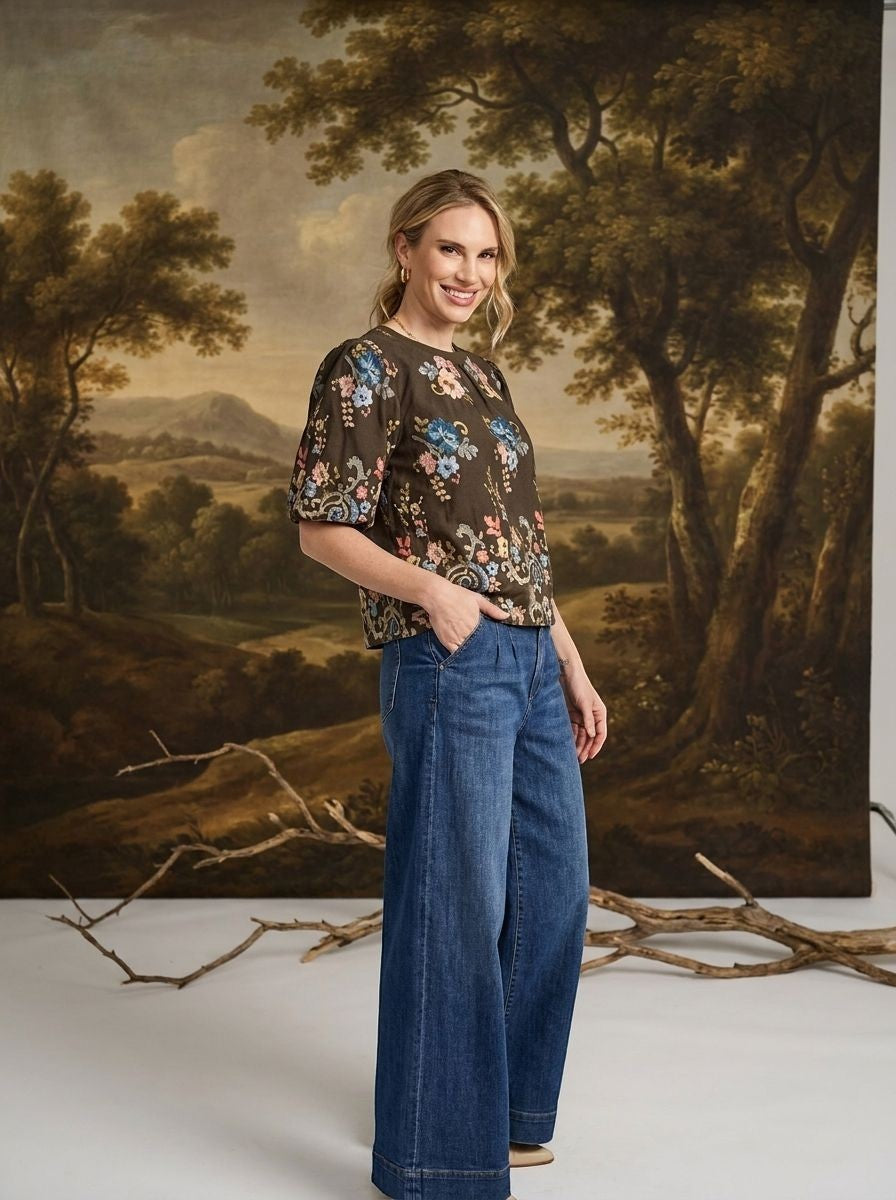 graced washed dark denim tie front pants with a relaxed wide-leg fit worn by a smiling woman in a floral top