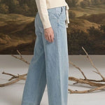 graced washed denim tie-front pants in light blue worn by a blonde model with a cream sweater and neutral heels