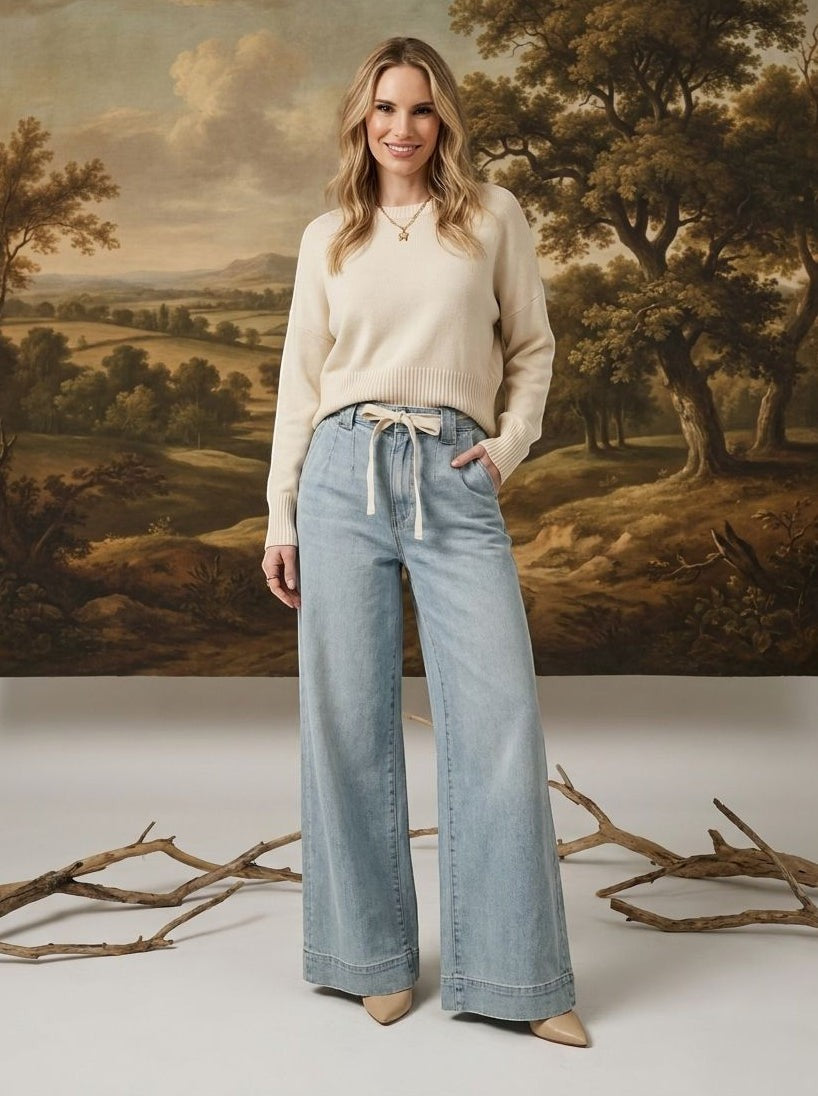 graced washed denim tie-front pants in light blue with a relaxed wide-leg fit worn by a model with a cream sweater