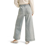 graced washed denim pants with a relaxed wide-leg fit and back pockets worn with a white top and ballet flats