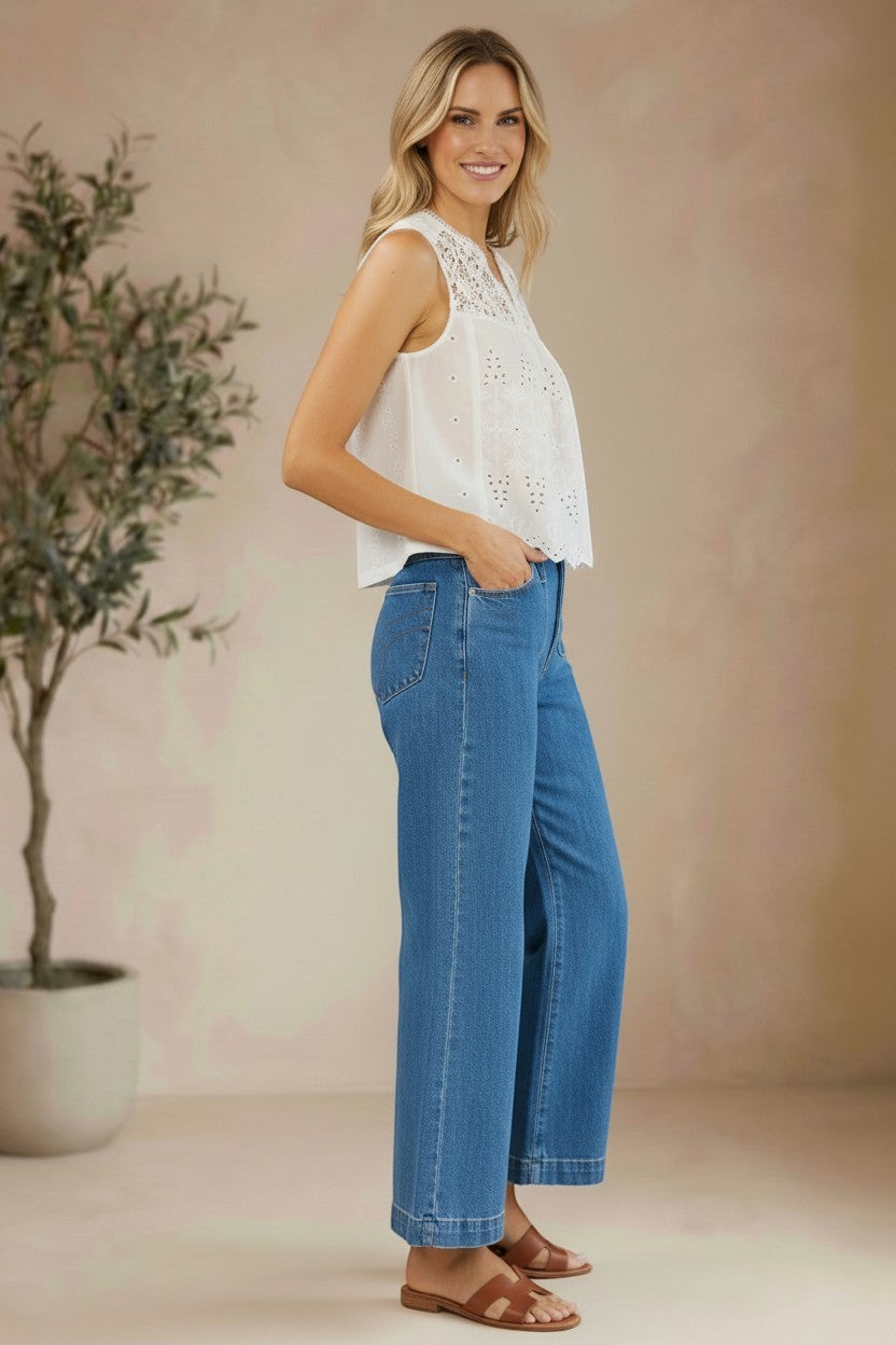 White sleeveless eyelet lace tank top by Lovestitch, featuring delicate eyelet details and a breezy, feminine blouse style.