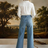 graced wide leg denim jeans with patch pockets worn by a model in a white shirt, back view