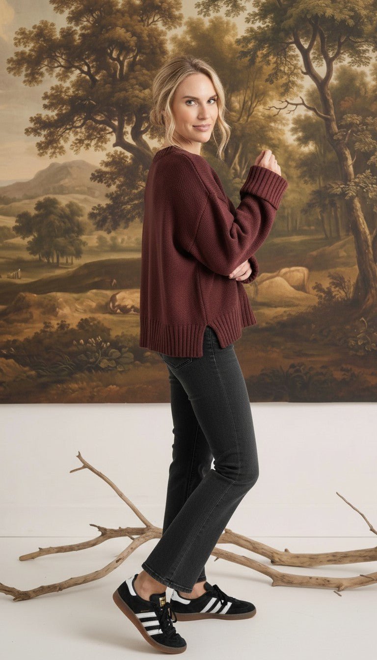 graced cocoa brown ribbed cuff sweater worn by a woman with black jeans and sneakers in a studio setting